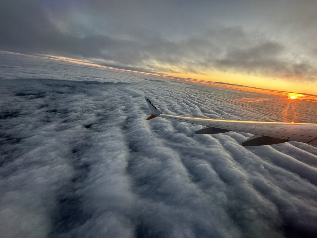 飞机在云上飞行，太阳开始露出